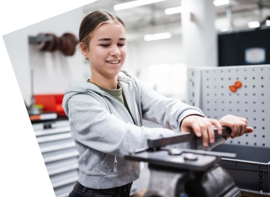 Schülerin werkt am am Schraubstock, in einer Werkstatt 