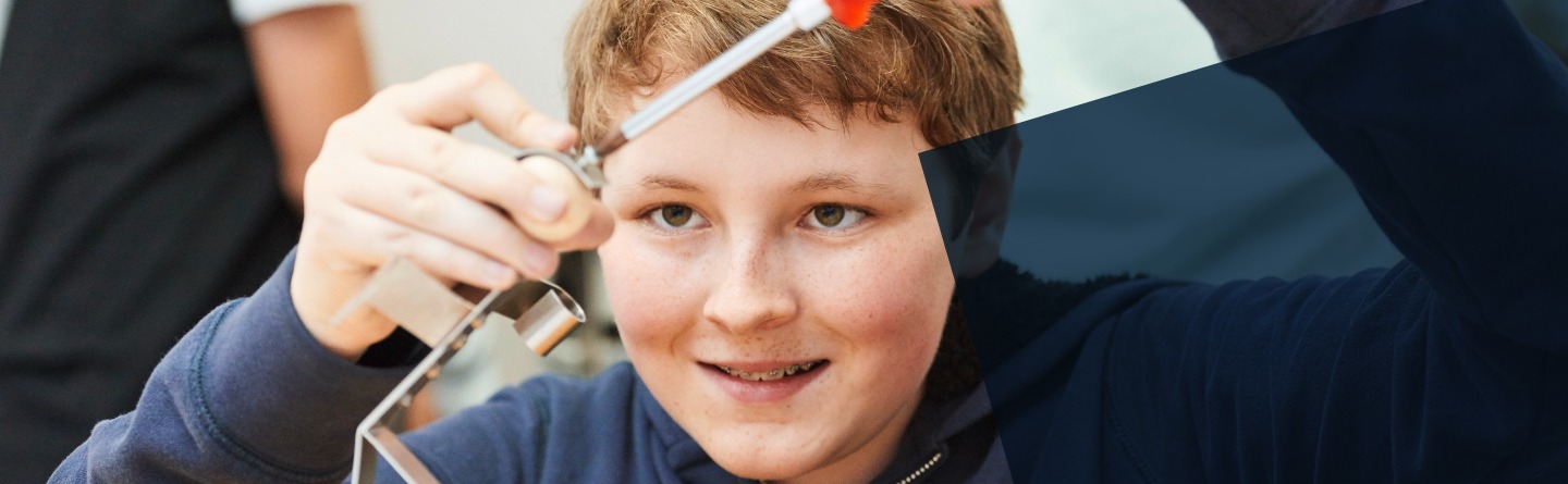 Schüler schraubt mit meinem Schraubenziehen ein Werkstück zusammen 