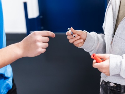 Person rechts hält ein Werkstück in der Hand und übergibt es an die Person Link 
