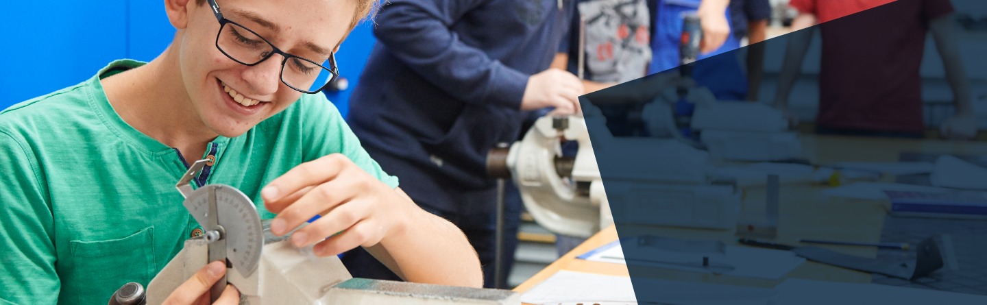 Schüler arbeitet an einem Werkstück und misst dessen Winkel aus 