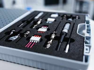 Werkzeugkoffer liegt geöffnet auf einem Tisch. Man sieht verschiedene Steckverbindungen und Werkzeuge 